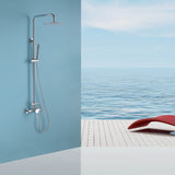 Modern chrome outdoor shower system installed by the ocean with sleek rainfall shower head and handheld sprayer