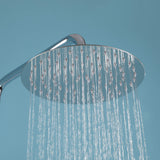 Close-up of chrome rainfall outdoor shower head with water flow, showing anti-clog nozzles