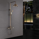 Antique brass exposed shower system installed against a dark gray bathroom wall