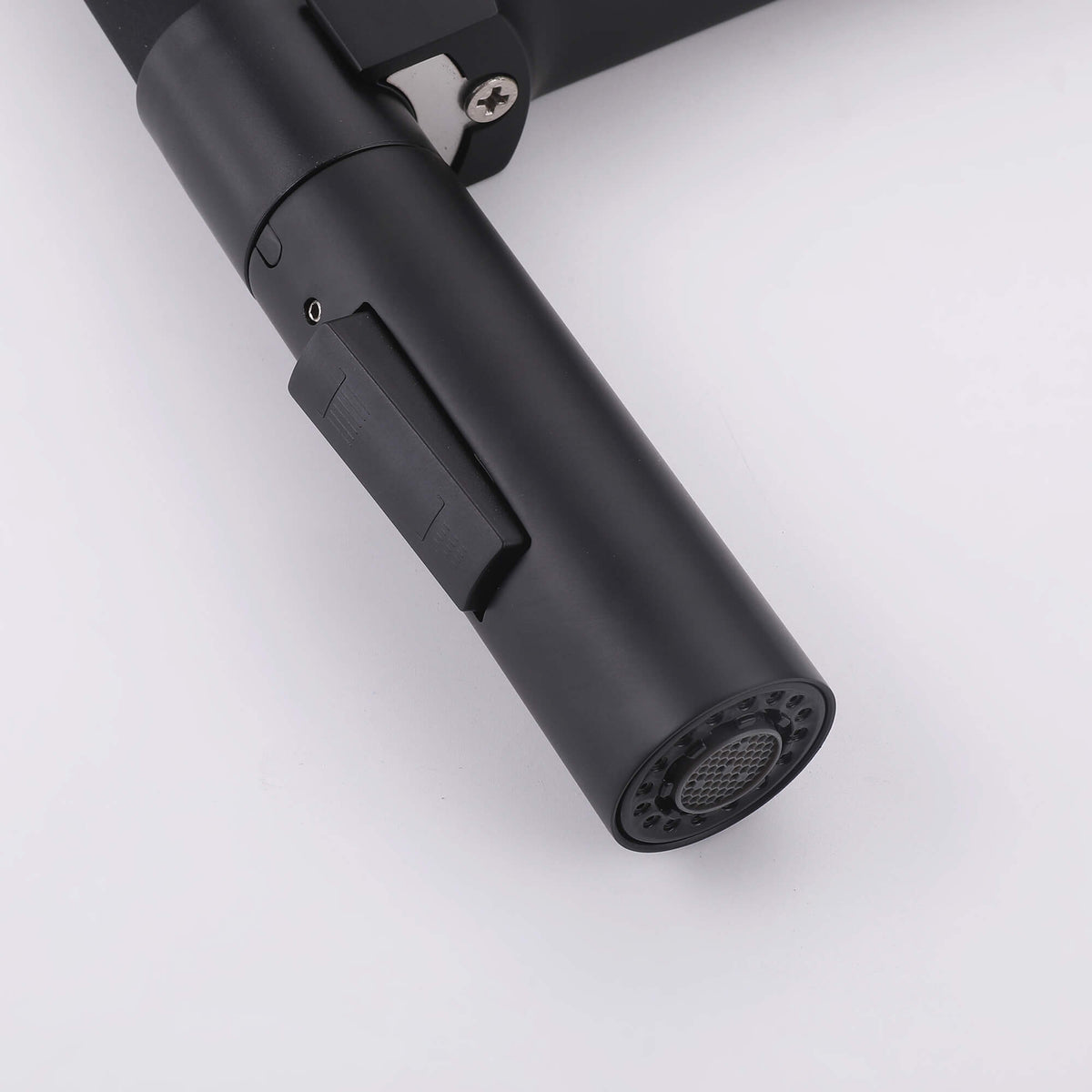 Close-up of black dual-mode faucet sprayer with switch button and aerator nozzle