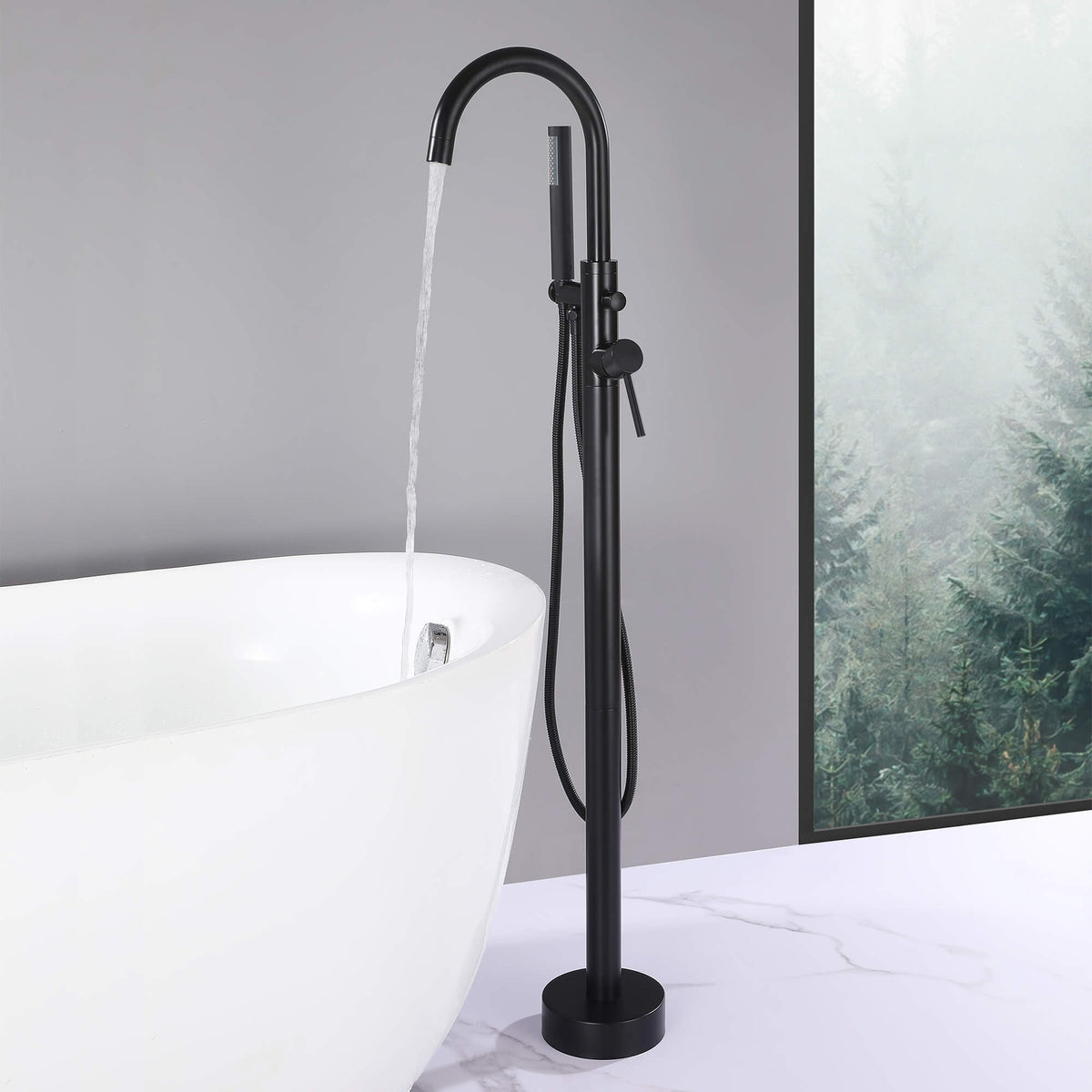 Matte black floor mount tub filler running water into a freestanding bathtub