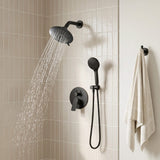 Modern tiled shower with the overhead spray operating beside a wall-mounted handheld shower and concealed mixer control