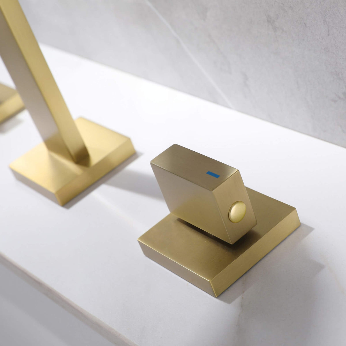 Brushed gold bathroom faucet handle control detail with modern square design