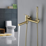 Brushed gold bathtub faucet with handheld shower dispensing water from the tub spout