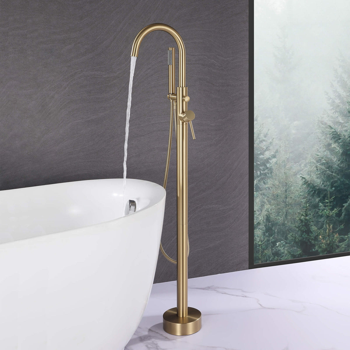 Brushed gold floor mount tub filler running water into a freestanding bathtub
