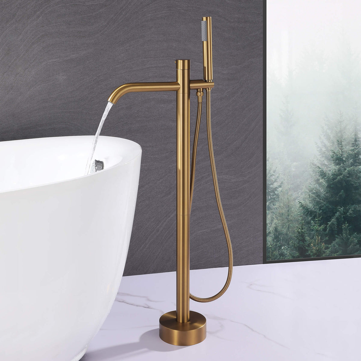 Brushed gold freestanding tub filler delivering water into a modern bathtub