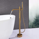 Brushed gold freestanding tub filler delivering water into a modern bathtub