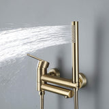 Brushed gold handheld shower spraying water beside the wall-mounted tub faucet