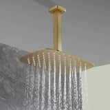 Close-up of brushed gold rainfall shower head spraying water, modern bathroom fixture.