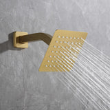 Close-up of brushed gold wall-mounted square shower head with strong spray stream.