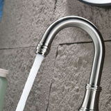 Close up of brushed nickel bathroom faucet spout with water saving aerator