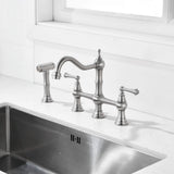 Brushed nickel bridge kitchen faucet with side spray installed on a kitchen sink