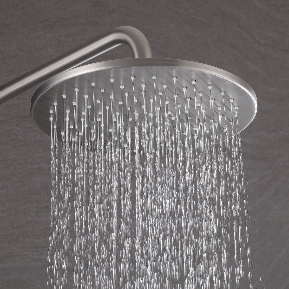 Close-up of brushed nickel round rain shower head with steady rainfall water flow