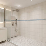 Brushed nickel rain shower system installed in modern bathroom with square shower head and handheld sprayer