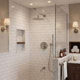 Brushed nickel rain shower system with round shower head, handheld shower and bathtub spout in a marble bathroom