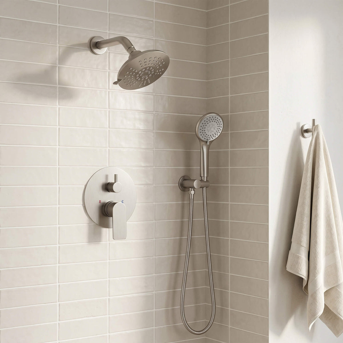 Wall-mounted dual shower set in brushed nickel with a round overhead head, handheld sprayer and concealed mixer controls