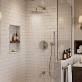 Brushed nickel shower system with rainfall water flow, hand shower and wall-mounted tub spout in a tiled bathroom