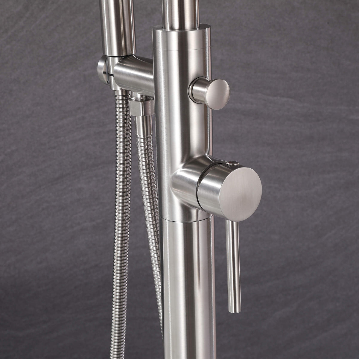 Close-up of brushed nickel tub filler control valve and diverter with shower hose
