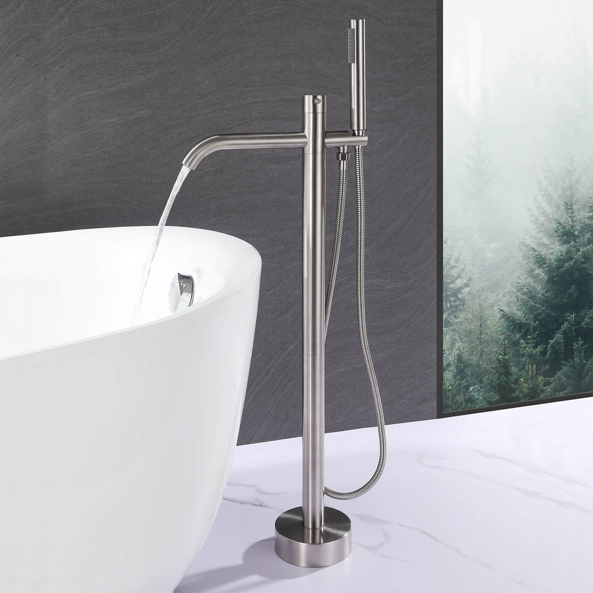 Brushed nickel freestanding tub filler delivering water into a modern bathtub