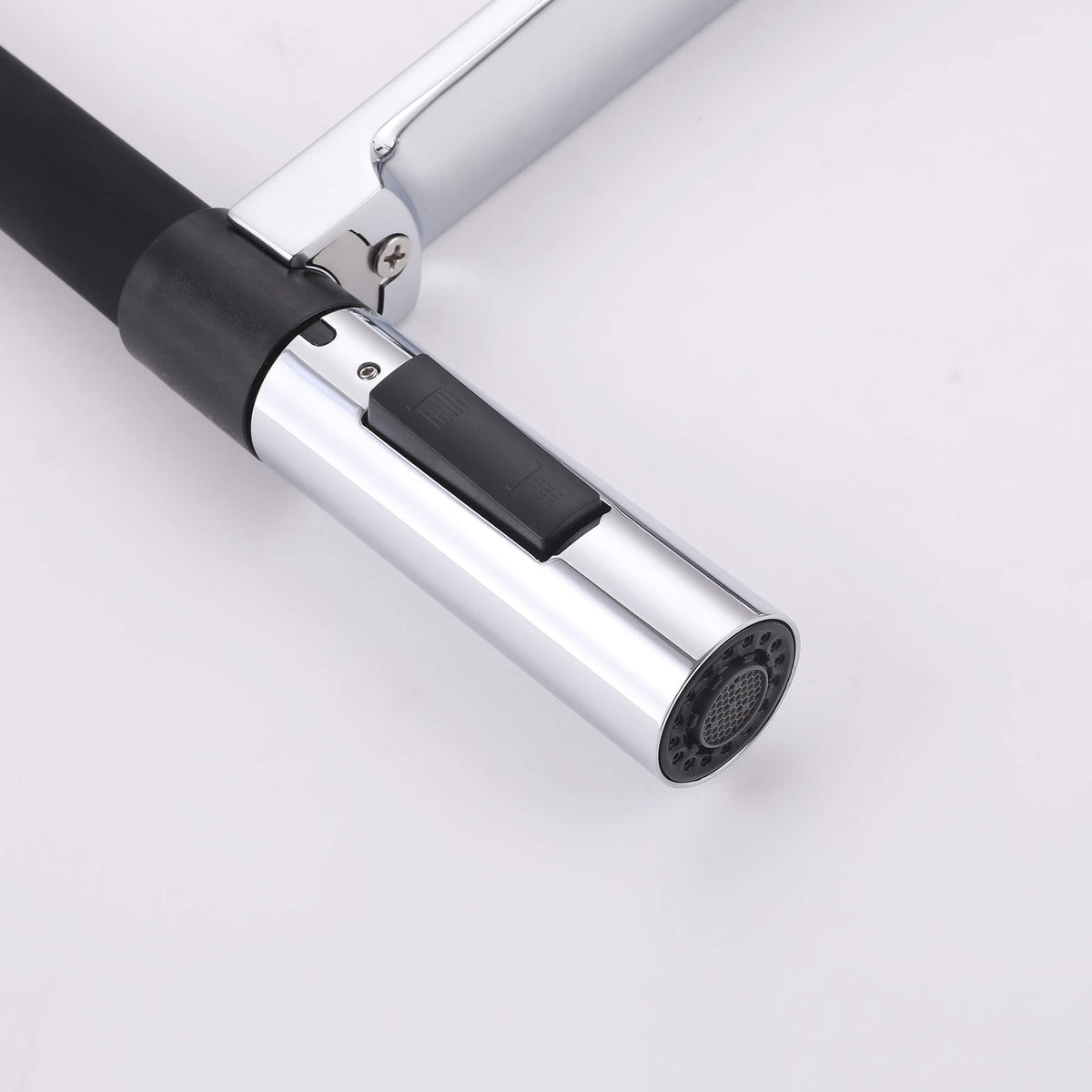 Close-up of chrome pull-down sprayer nozzle with black spray and stream switch