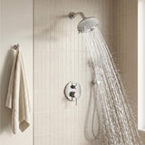 Polished chrome overhead fixture delivering a wide spray beside a coordinated handheld unit in a tiled bathroom