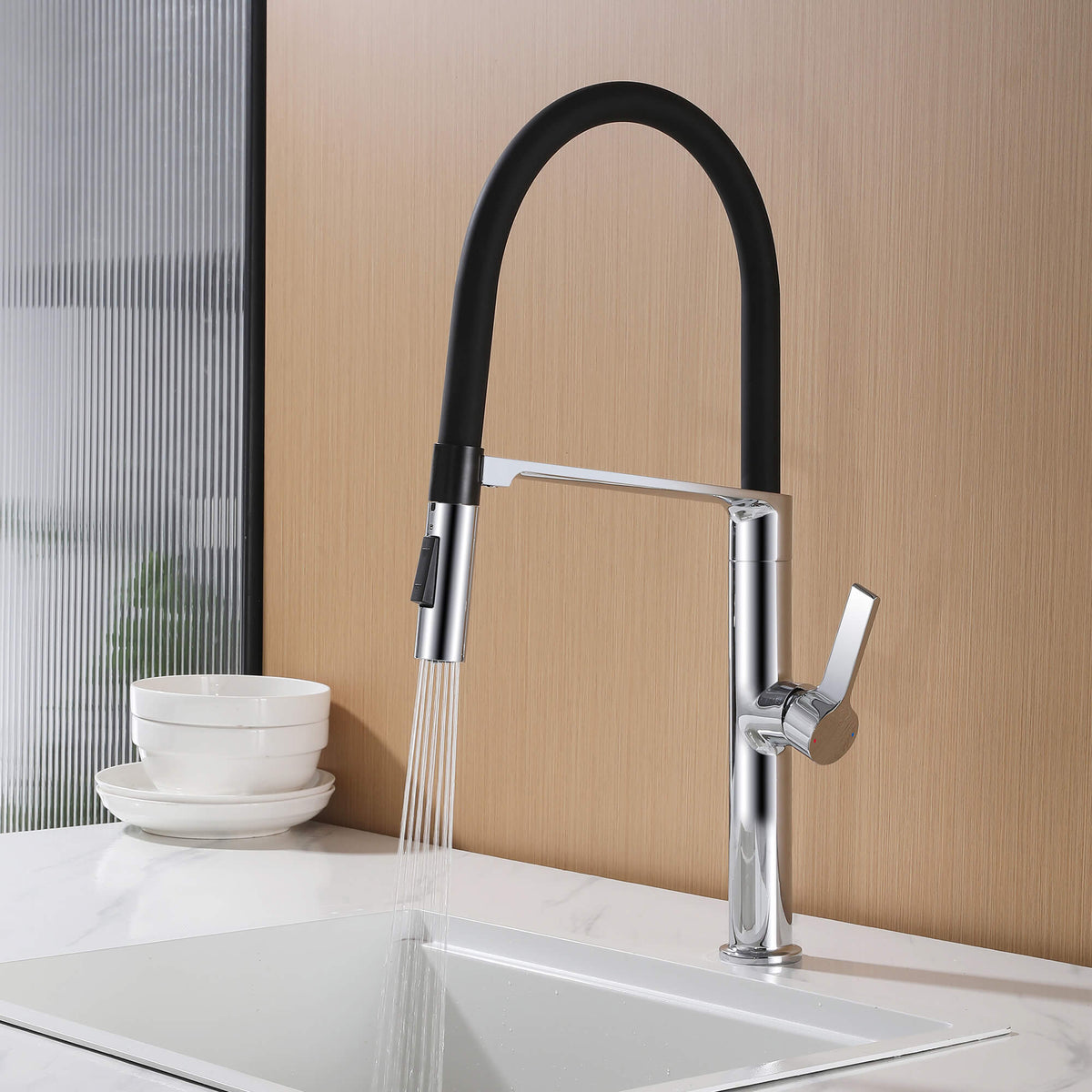 Chrome pull-down faucet using spray rinse function over a modern white kitchen sink