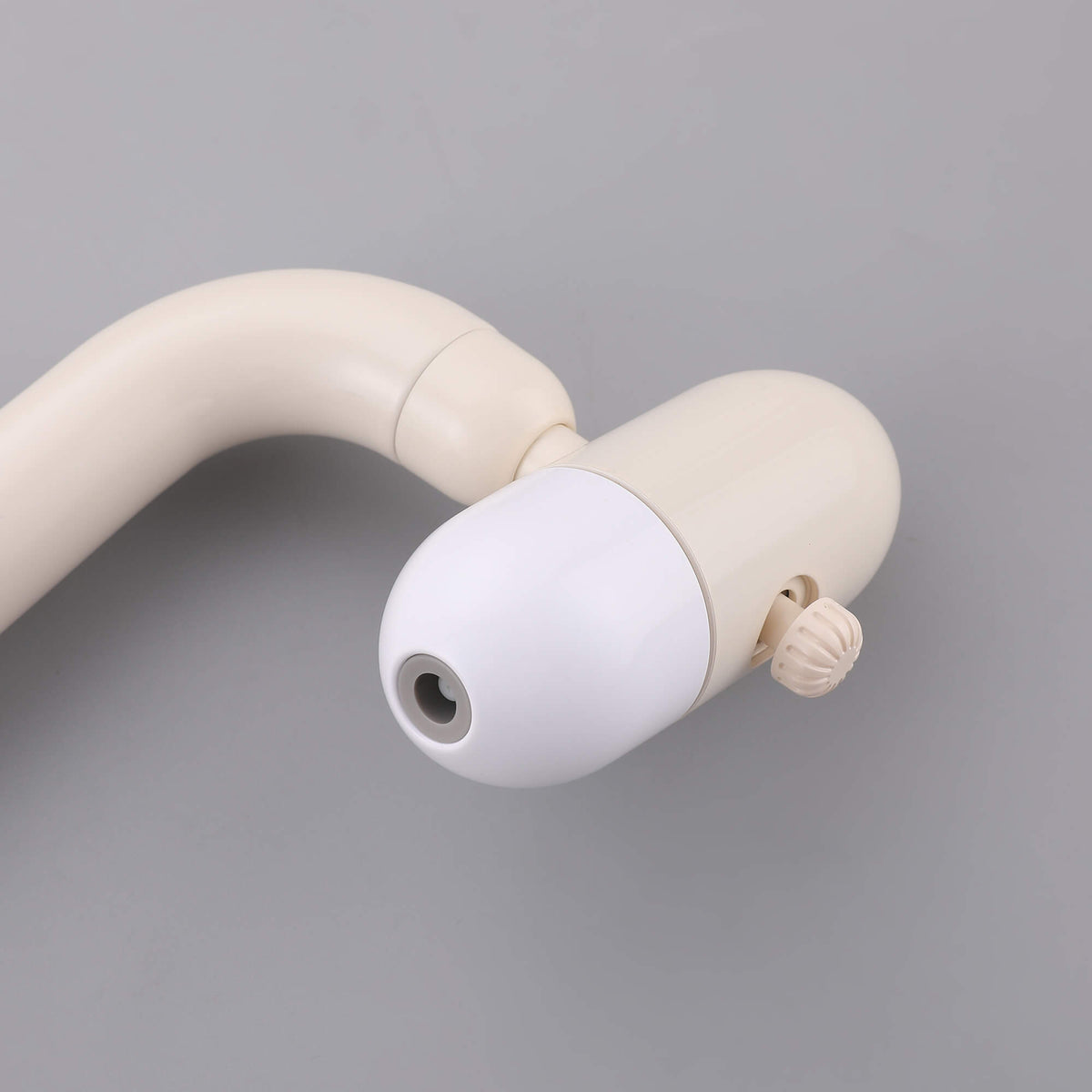 Close-up view of cream white faucet spray head with adjustable nozzle design