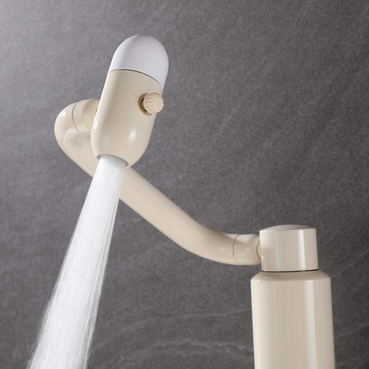 Close-up view of water flowing from cream white faucet spray head