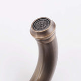 Close-up of the curved bathroom faucet spout and built-in aerator