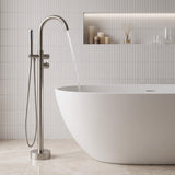 Floor mounted tub filler faucet in a modern minimalist bathroom with freestanding bathtub