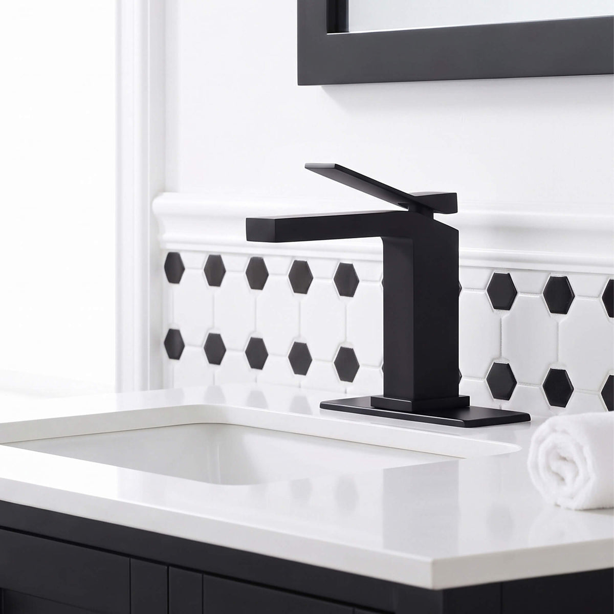 Modern matte black bathroom faucet installed on a white vanity sink with contemporary bathroom design