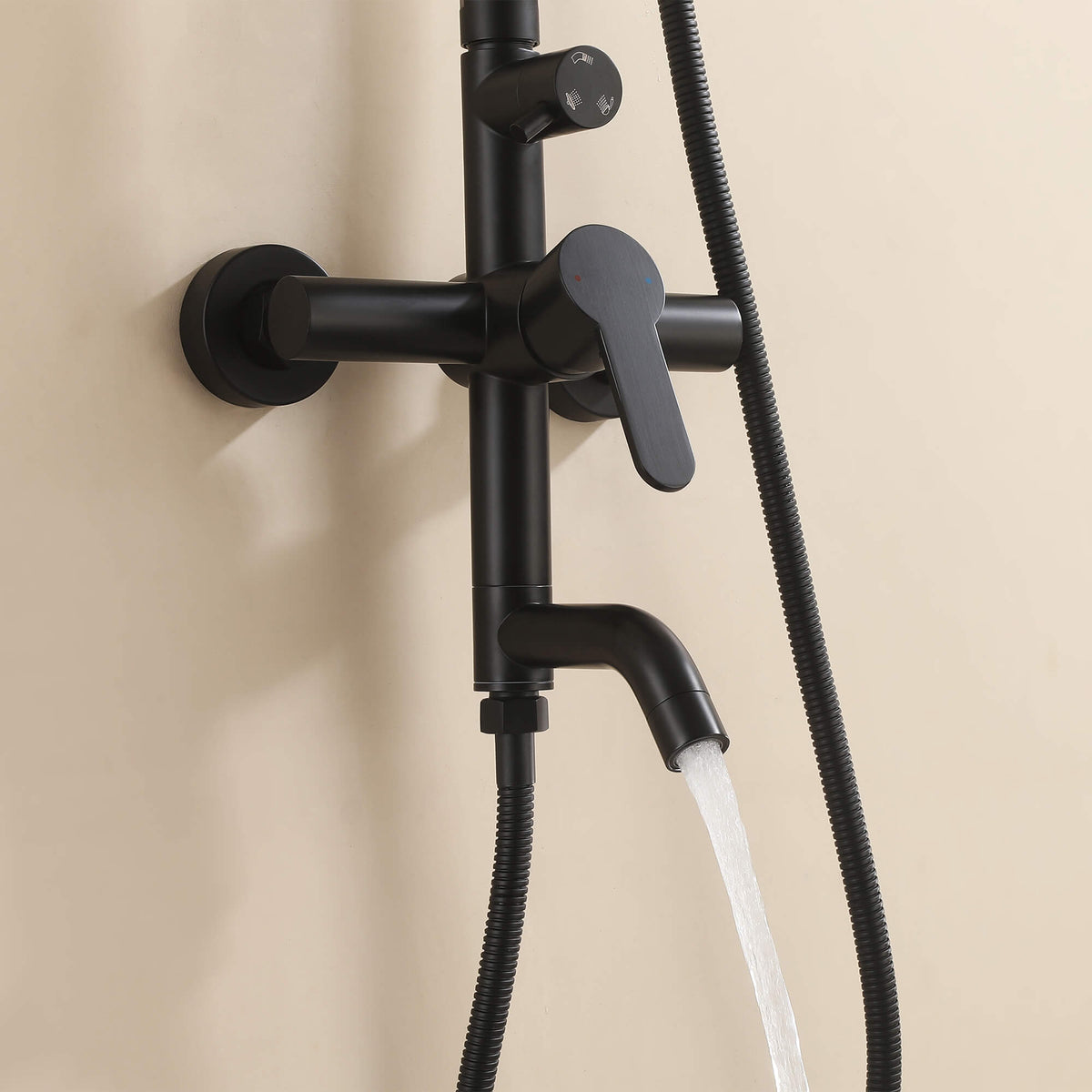 Water flowing from the curved tub spout of the JK0562 matte black outdoor shower faucet system.