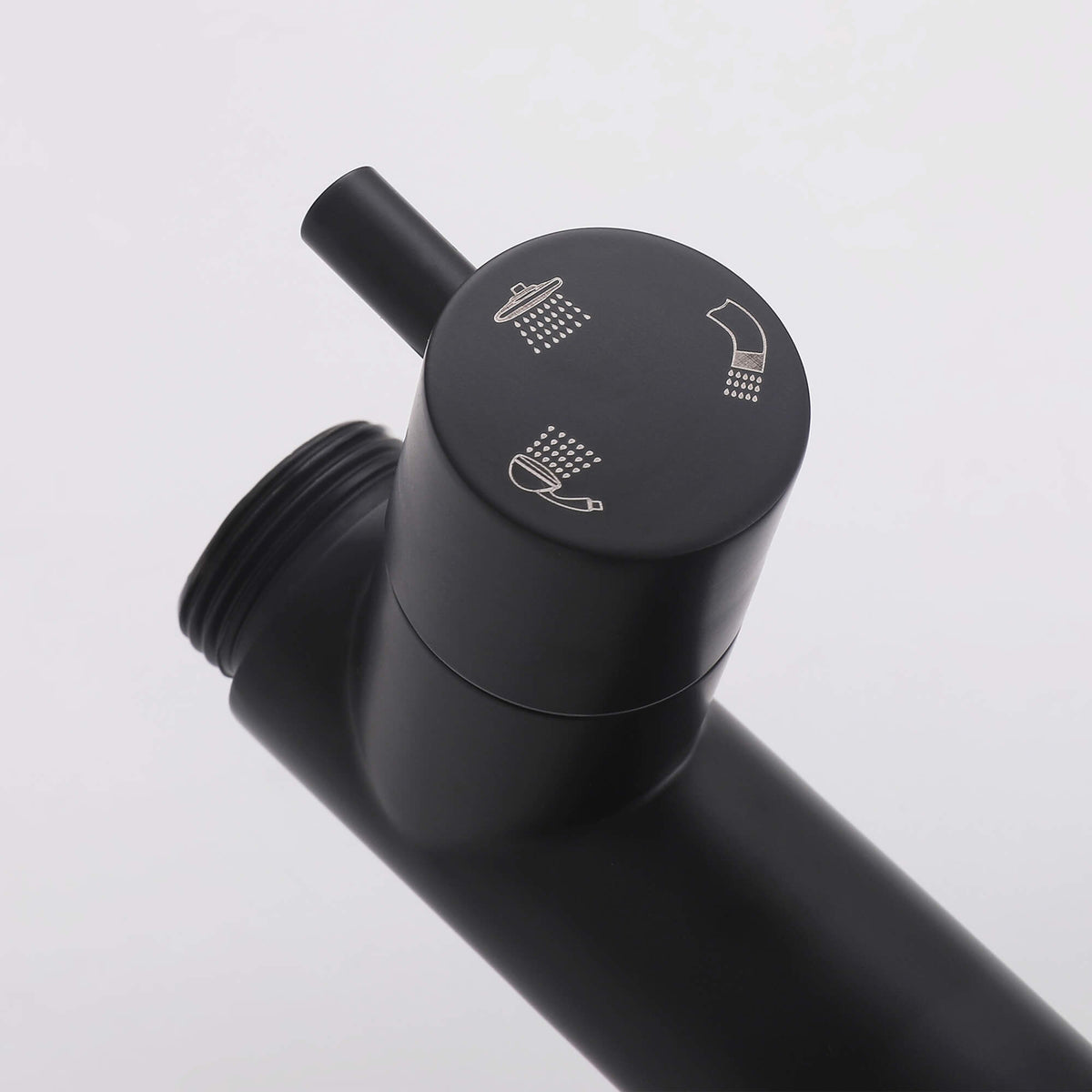 Detail of the JK0562 matte black outdoor shower diverter knob with engraved rainfall shower, handheld sprayer, and tub spout icons.