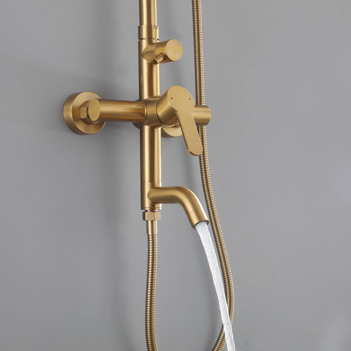 Brushed gold JK0563 outdoor shower system with water flowing from the tub spout, showing the wall mounted mixer and handheld shower hose.