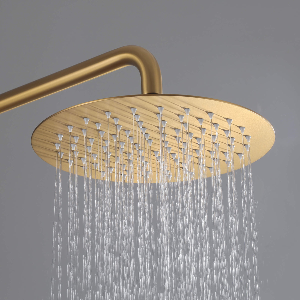 Water flowing from the round brushed gold rainfall shower head of the JK0563 316 stainless steel outdoor shower system.