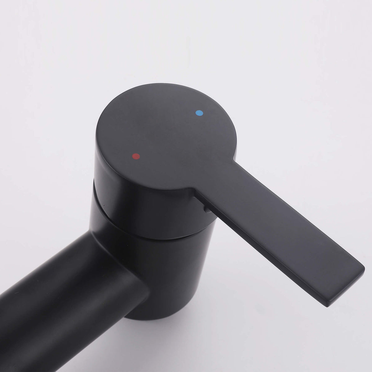 Close-up of the matte black shower mixer handle with red and blue hot and cold water indicators.