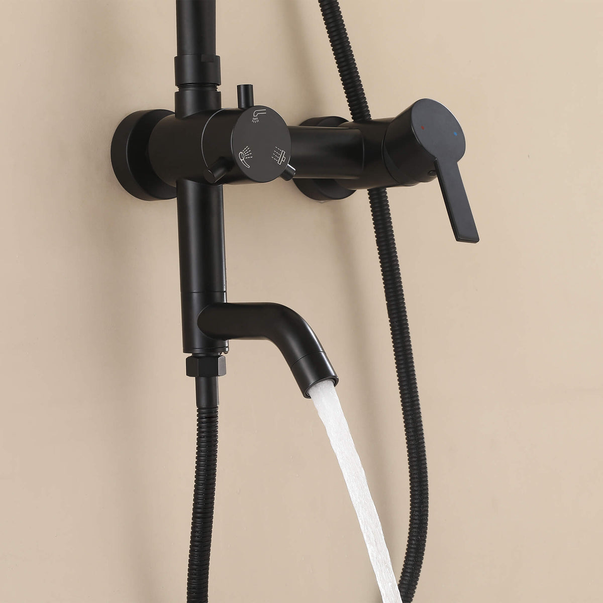 Water flowing from the curved tub spout of the JK0565 matte black wall-mounted outdoor shower system.