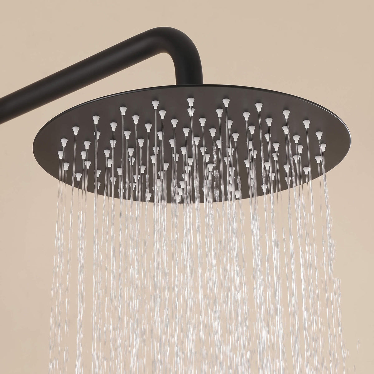 Close-up of the round rainfall shower head delivering an even shower spray from the matte black outdoor shower system.