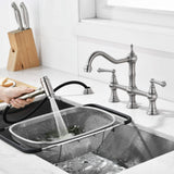 Kitchen bridge faucet side sprayer in use for rinsing food and cleaning the sink