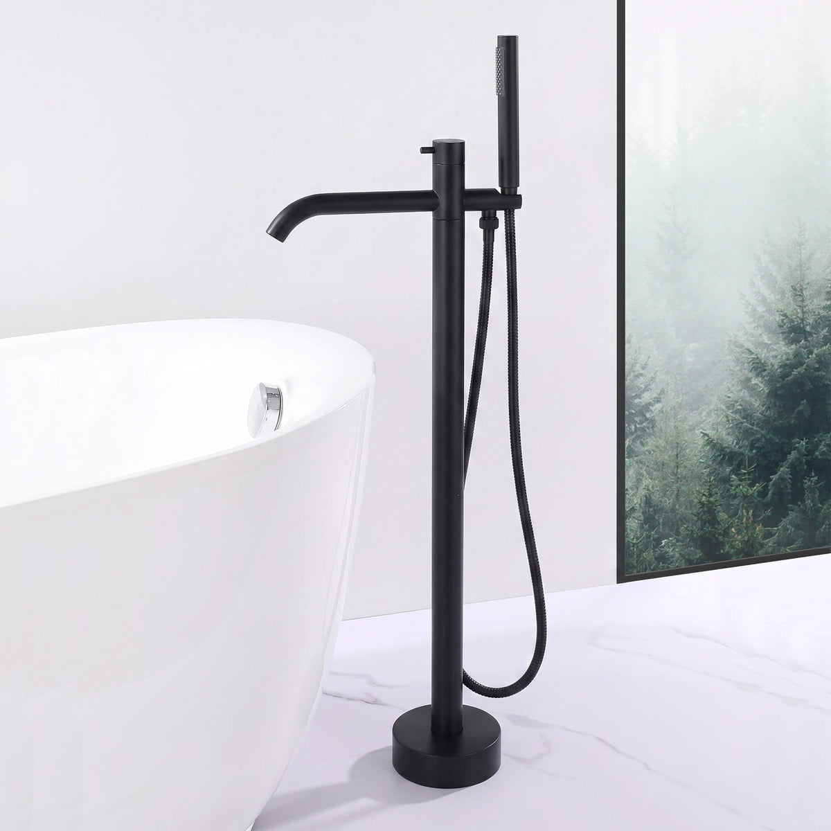 Matte black floor mount tub filler with handheld shower beside a freestanding bathtub