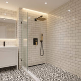 Matte black and brushed gold rain shower system installed in modern bathroom with square rainfall shower head and handheld shower