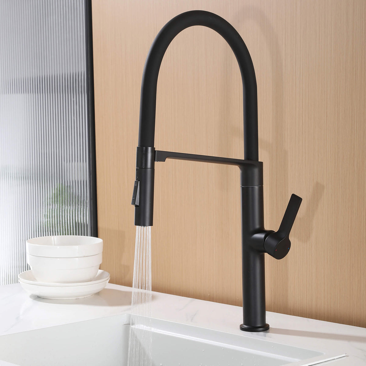 Matte black kitchen faucet using spray rinse mode with pull-down sprayer over sink