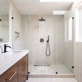 Matte black rain shower system with overhead rainfall shower head and handheld shower in a modern walk-in shower