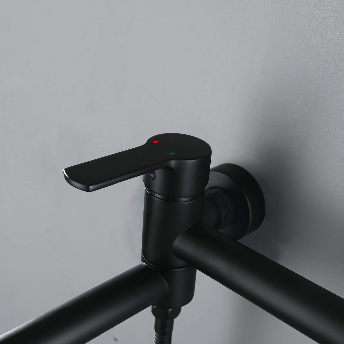 Close-up of single-handle matte black wall-mounted bathtub faucet control