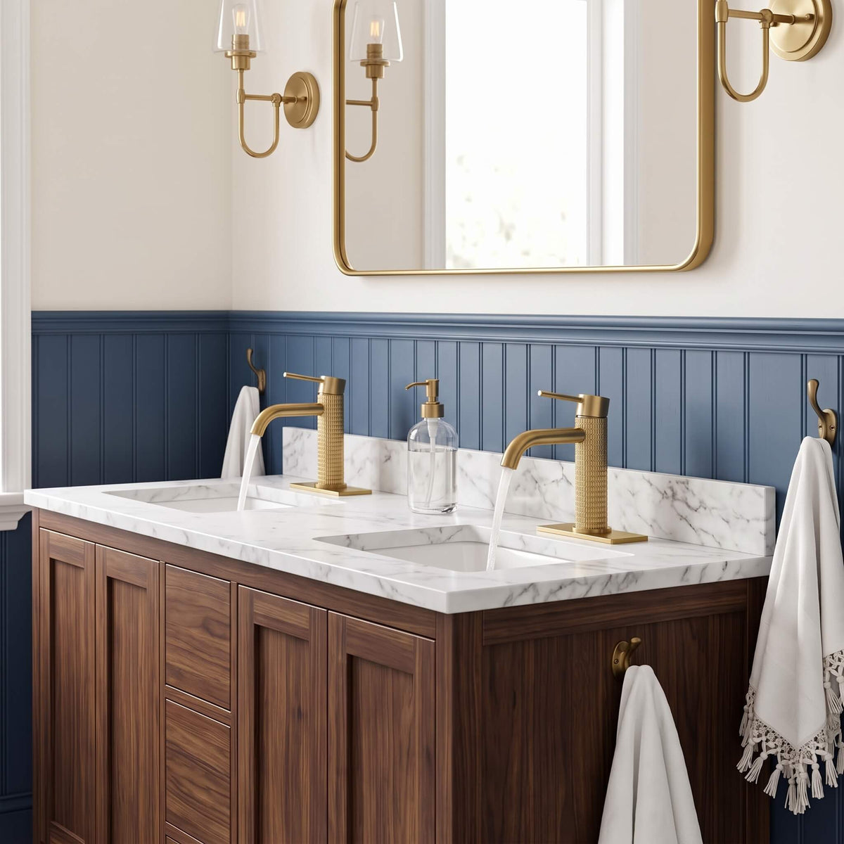 Modern brushed gold bathroom faucet on marble countertop with wood vanity cabinet