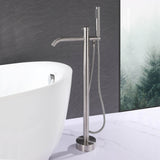 Modern brushed nickel floor mount tub filler with handheld shower beside a freestanding bathtub
