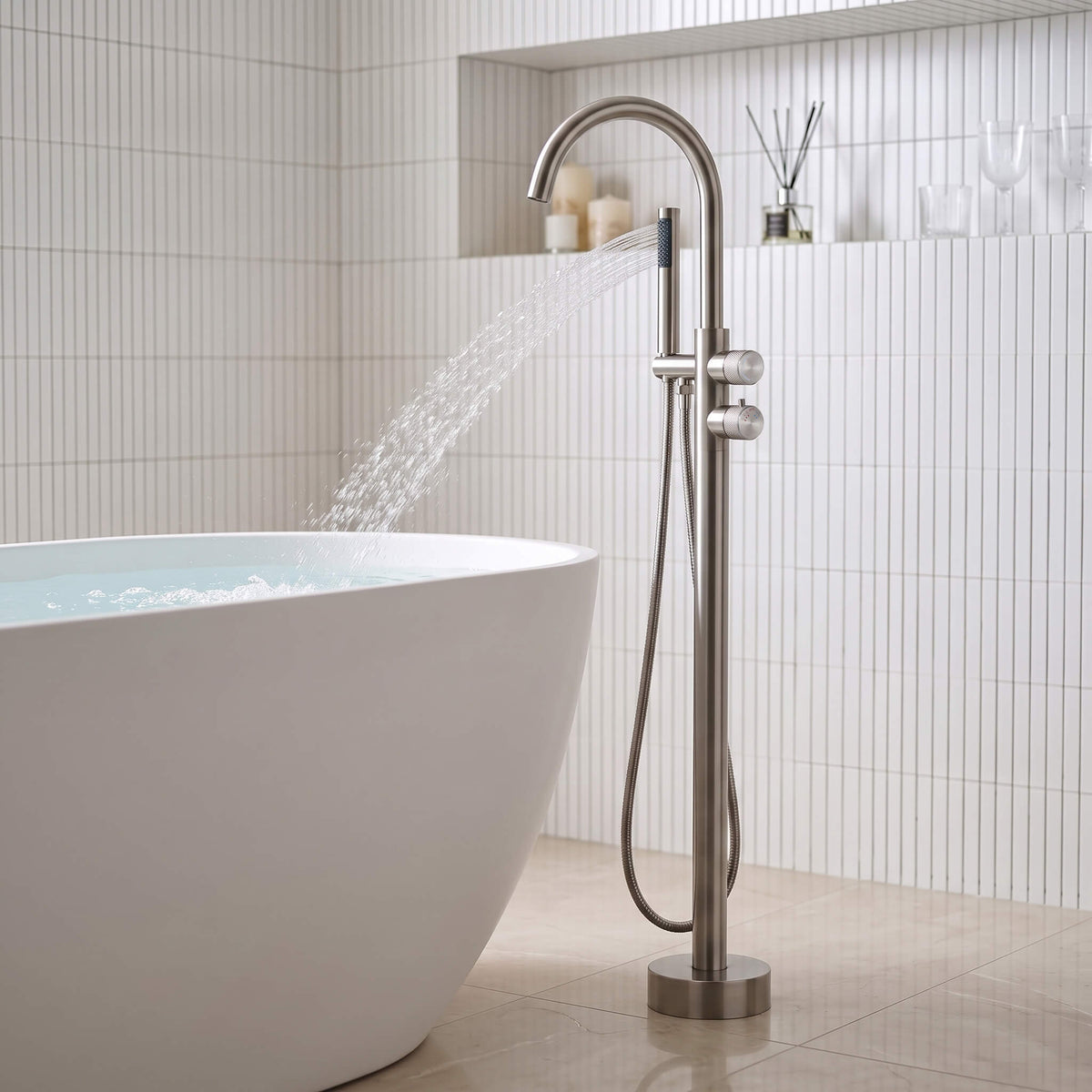 Brushed nickel freestanding bathtub faucet with elegant water flow next to modern bathtub