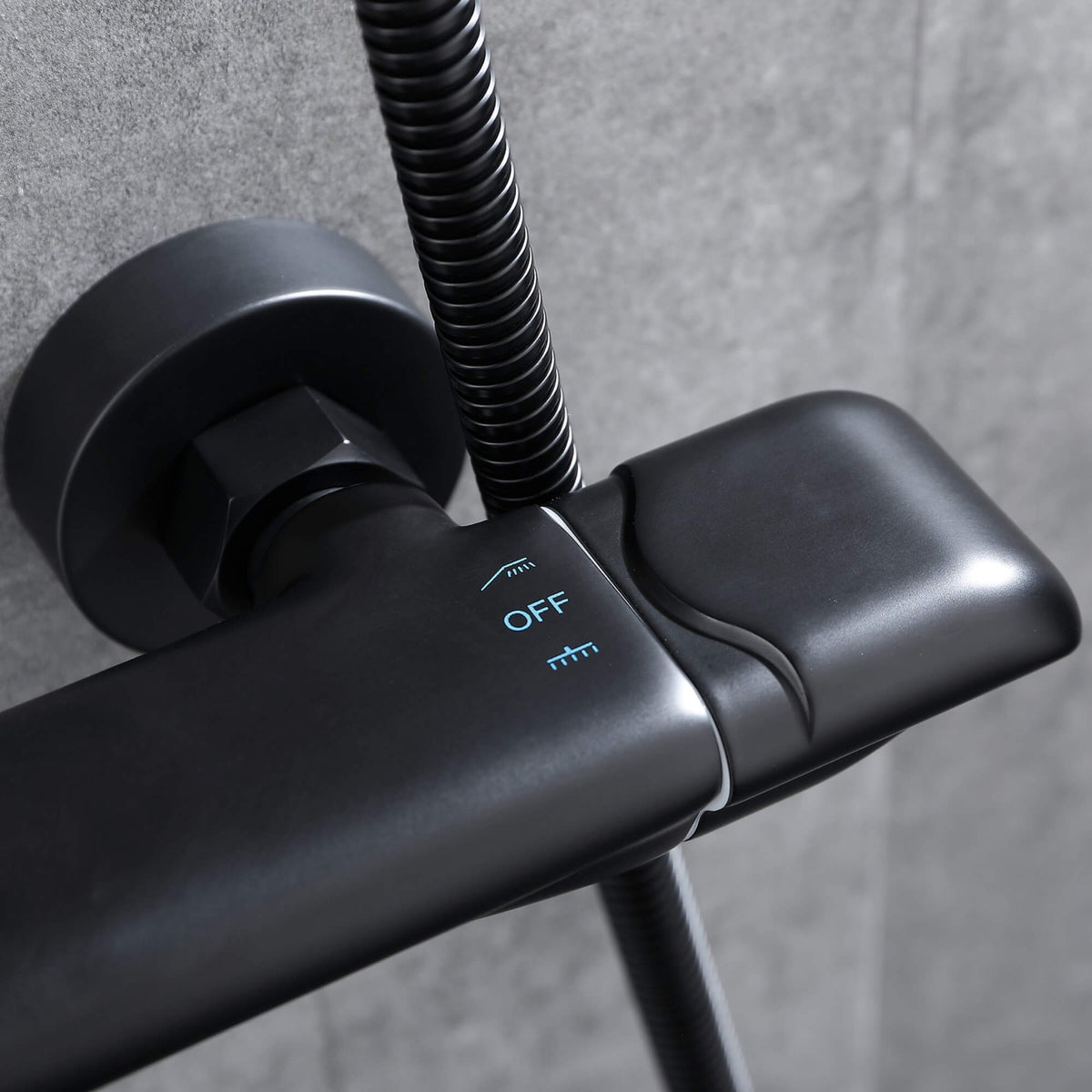 Close-up of the shower diverter control on a matte black thermostatic shower system