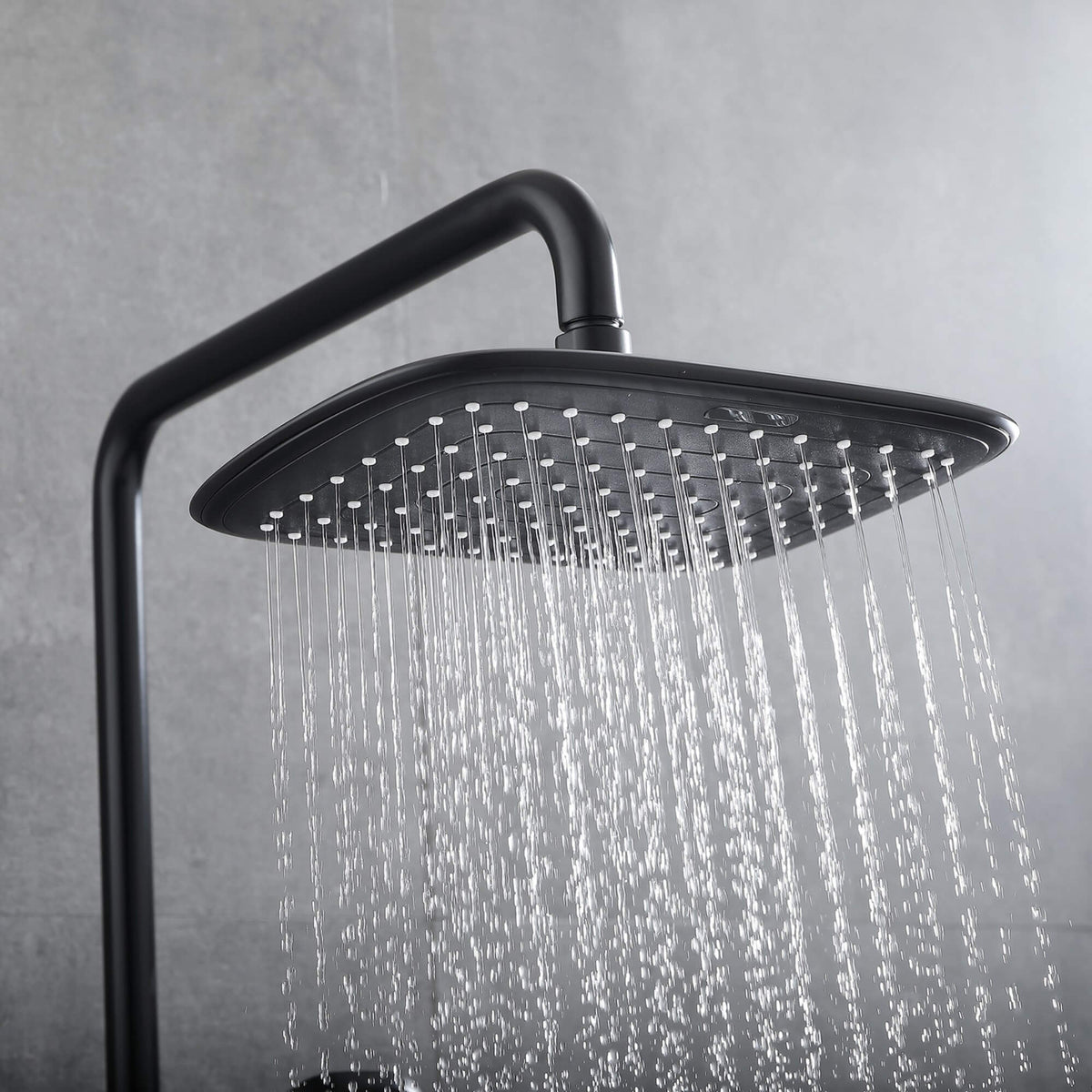 Close-up of square matte black rain shower head with even rainfall water flow