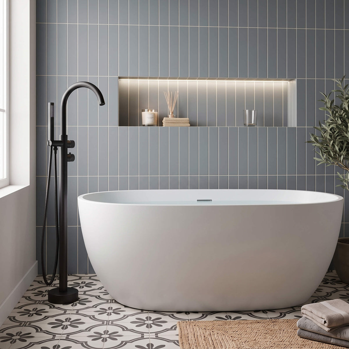 Matte black freestanding tub faucet with hand shower beside a modern white bathtub